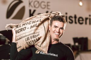 Mand bærer kaffesæk i kaffebar