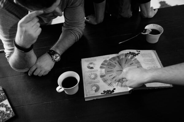 Personer diskuterer diagram over kaffevarianter