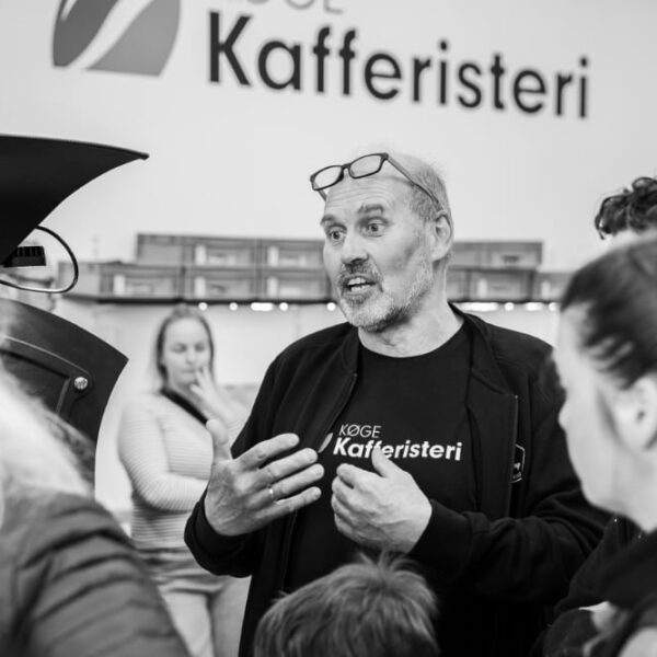 Mand taler til gruppe ved kafferi.