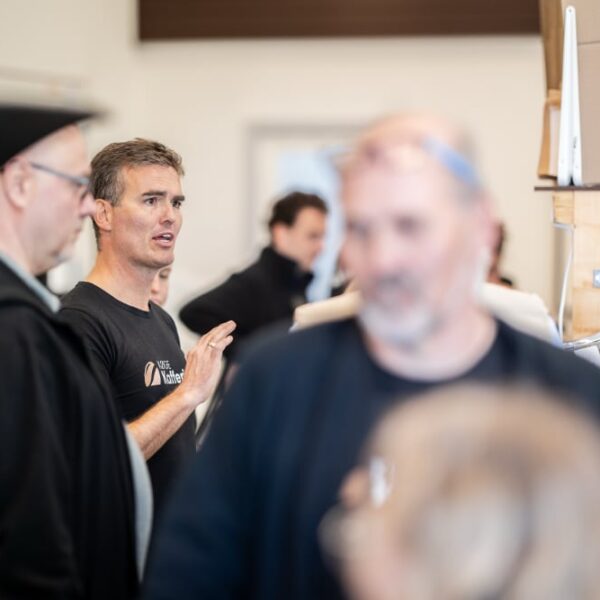 Mænd i samtale på travl arbejdsplads